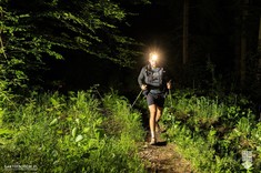 Zdjęcie z ultramaratonu Joga-Kora przedstawia zawodnika biegnącego nocą