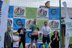 Zawodnicy podczas dekoracji zwycięzców. Na drugim miejscu podium Daniel Słyś z Klubu Biegacza PRz